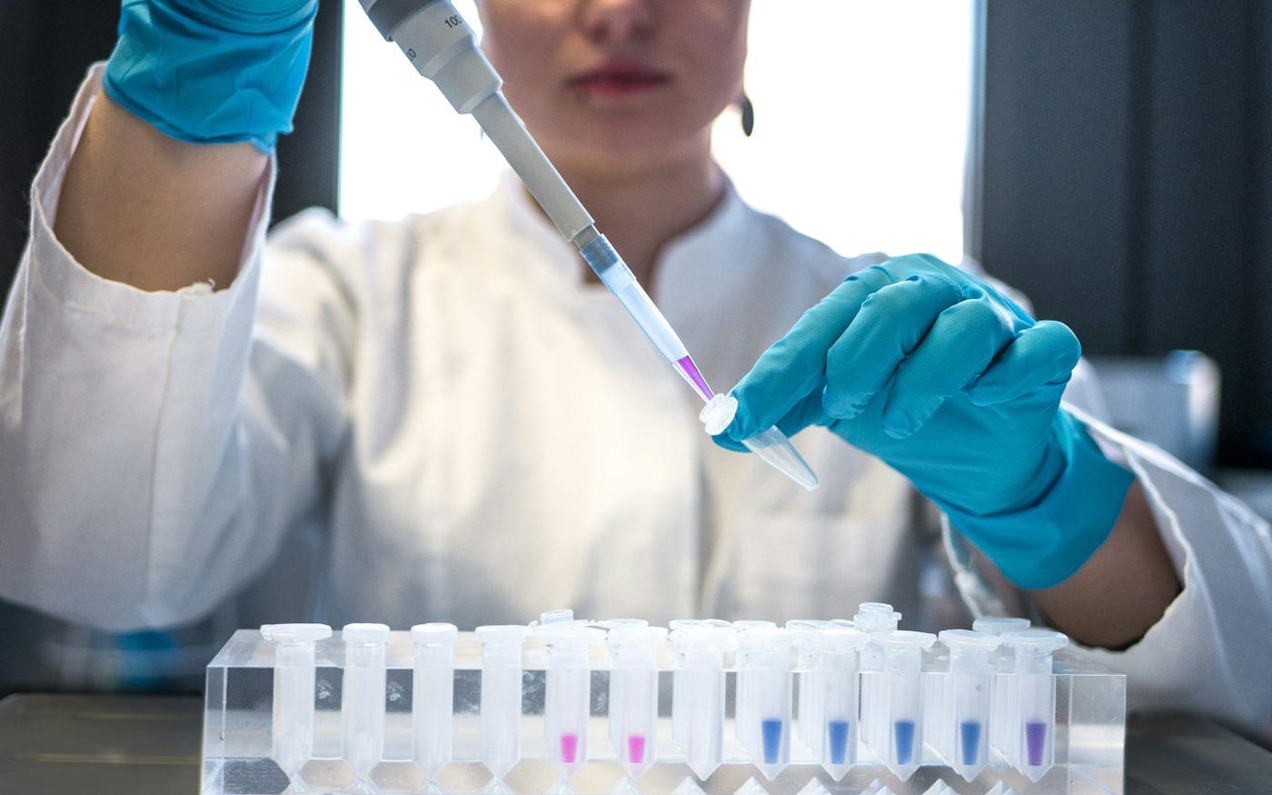 Scientist using a pipette with test tubes