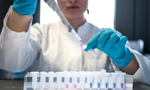 Scientist using a pipette with test tubes