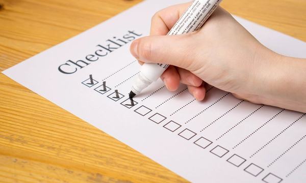 Hand ticking items on an audit checklist