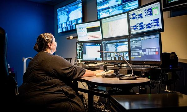 Operator monitoring IT systems on several screens
