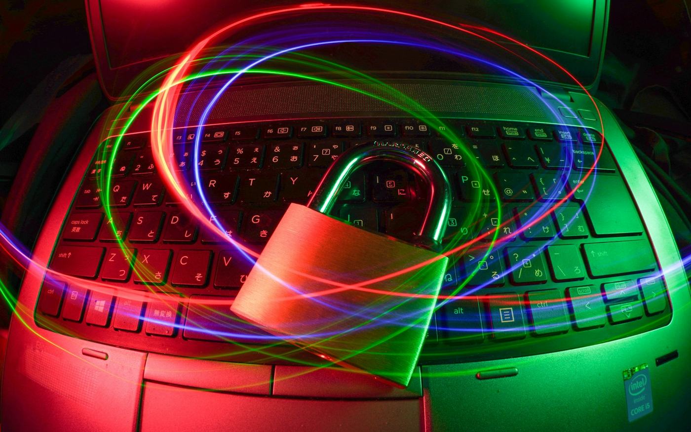 Padlock on a laptop keyboard with light trails
