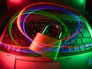 Padlock on a laptop keyboard with light trails
