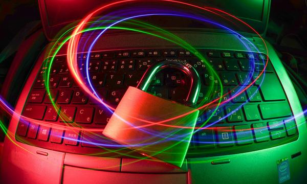 Padlock on a laptop keyboard with light trails