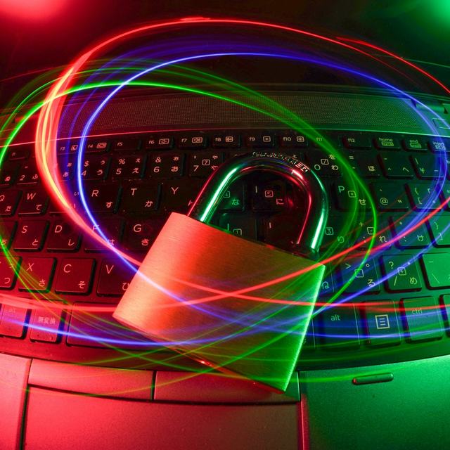 Padlock on a laptop keyboard with light trails