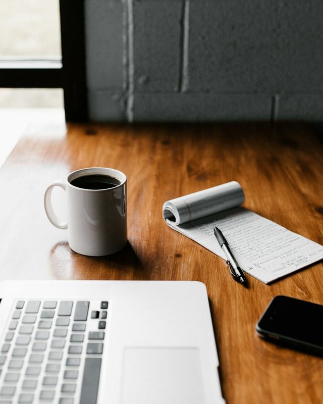 Laptop, notebook and coffee on a desk